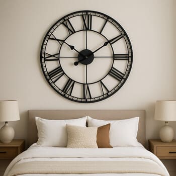 Bedroom wall with a single large clock above the headboard