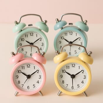 Group of pastel alarm clocks in soft blue, mint and sand colors