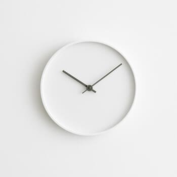 Minimal white wall clock on a plain navy wall